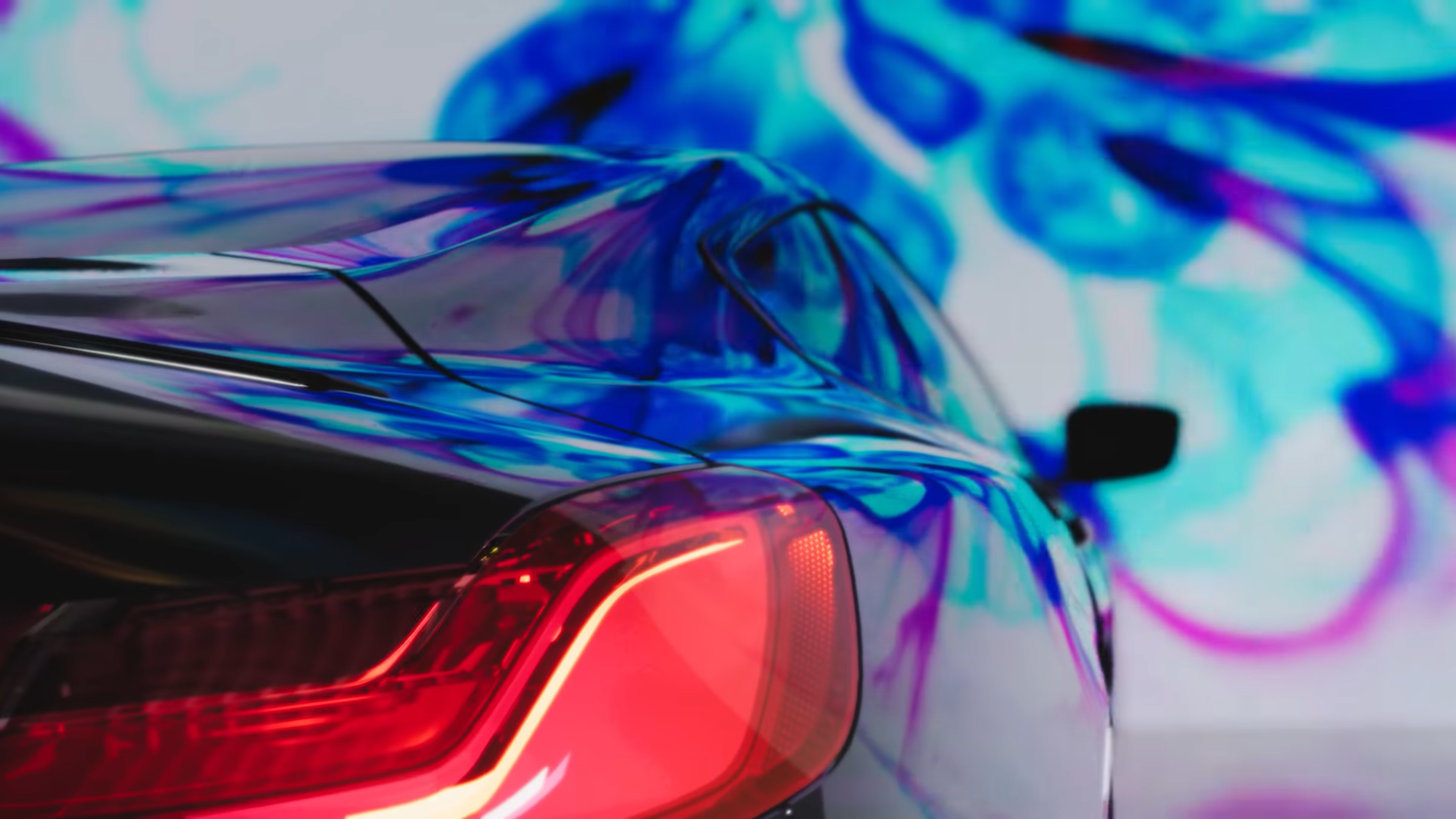 A car rendered with ray-traced reflections against a colourful backdrop